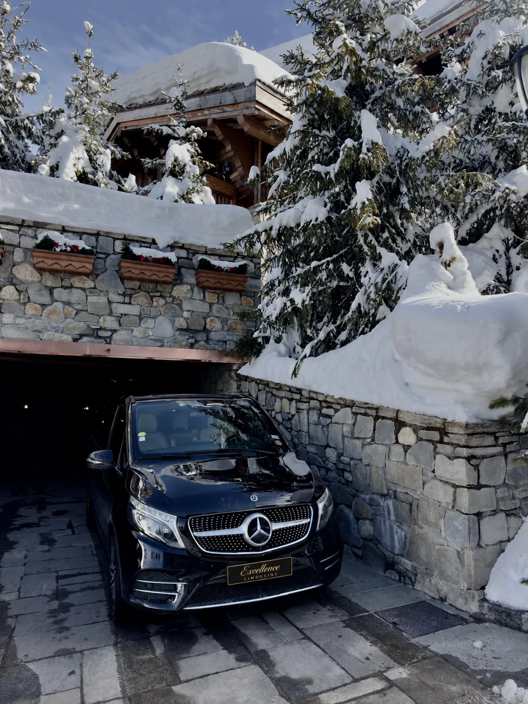 Mercedes Classe V dans une entrée bordée de murs en pierre et de neige.