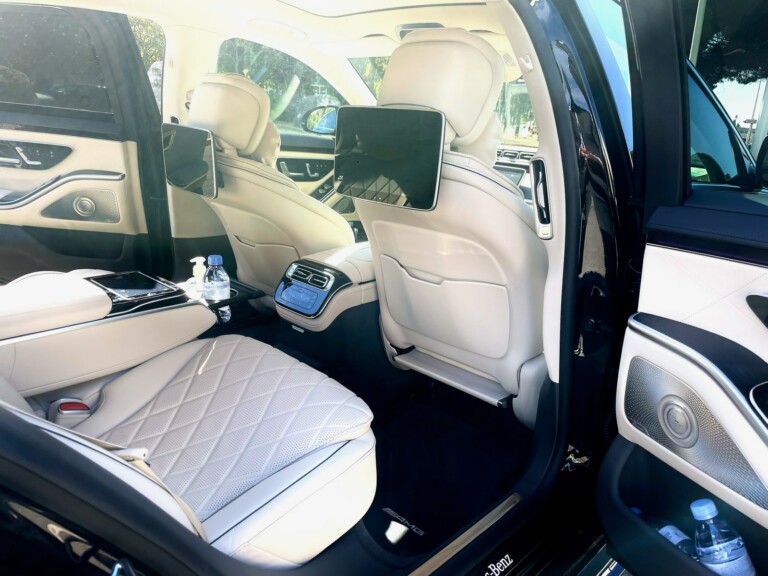 Espace arrière d’une Mercedes Classe S avec écran et sièges en cuir clair
