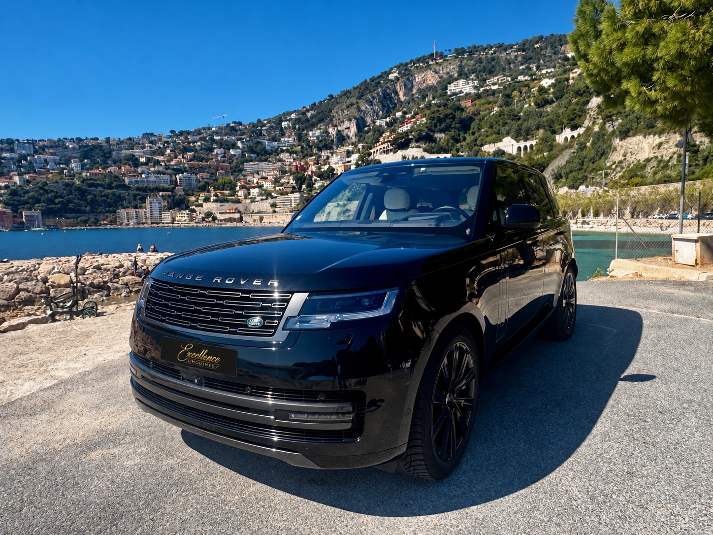 Range Rover noir en bord de mer avec plaque noire et logo Excellence Limousines doré