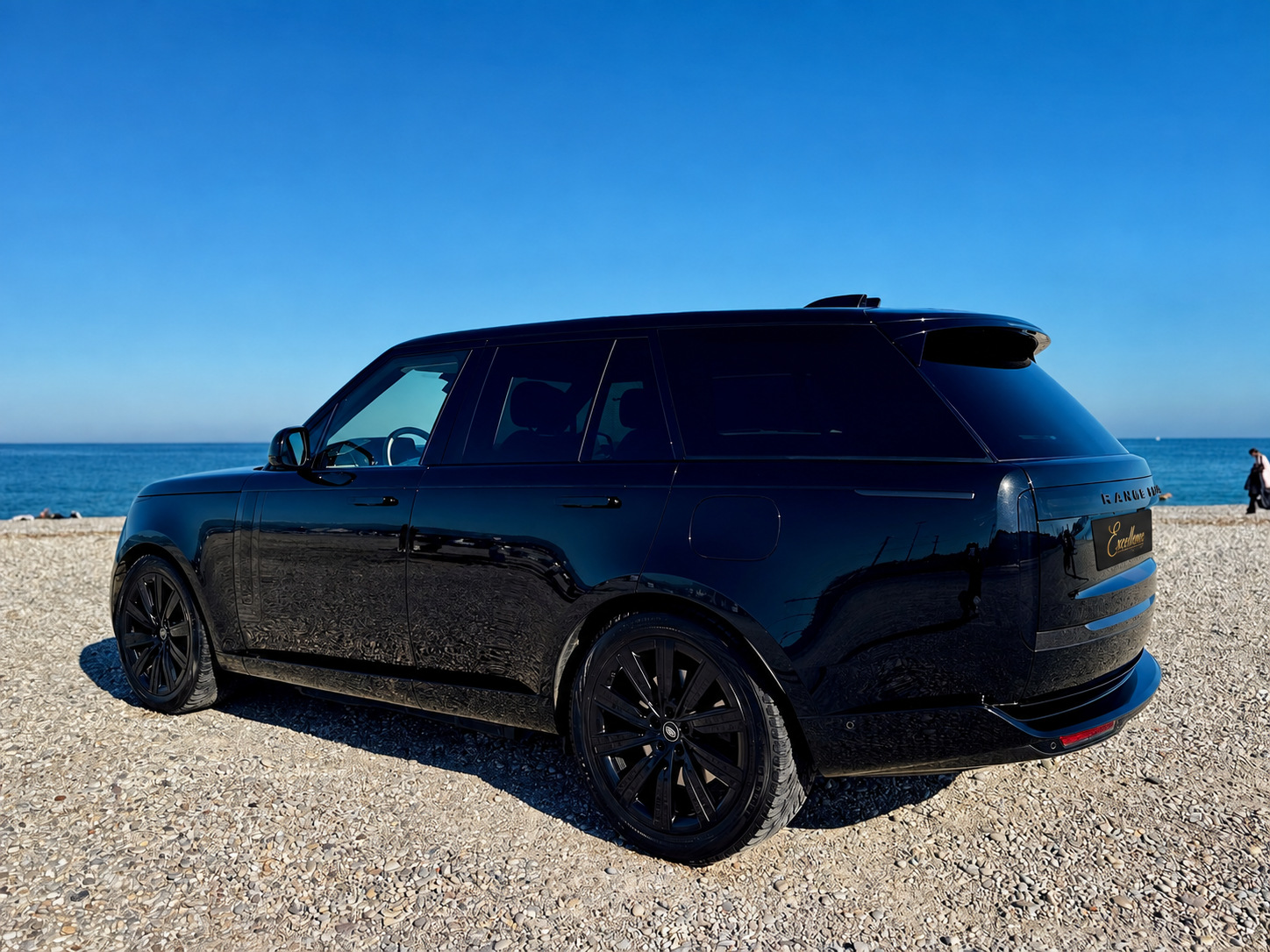 Schwarzer Range Rover schräg von hinten am Meer