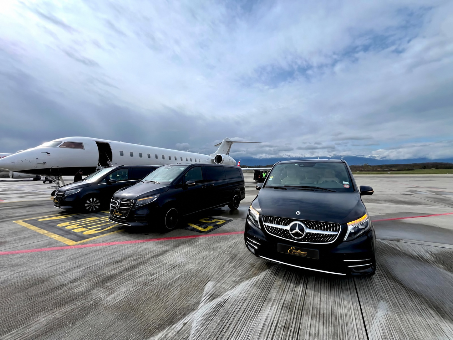 Three Mercedes V-Class vans beside a private aircraft
