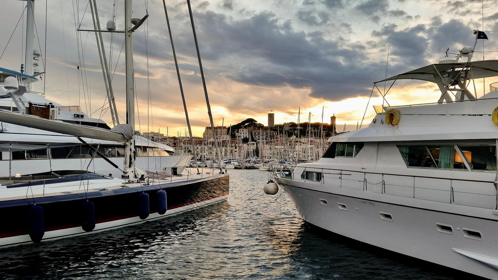 Yachts moored in a marina at dusk