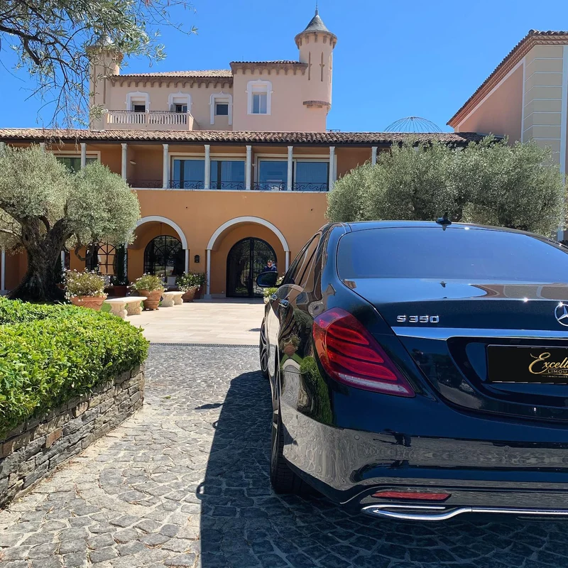Rear view of a black Mercedes S-Class outside the ochre façade of Château de la Messardière in 2020.